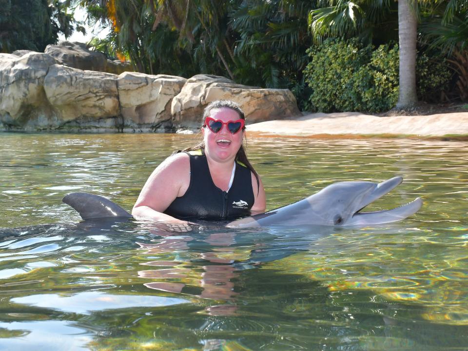 megan posing for a photo with a dolphin at discovery cove marine life park in orlando