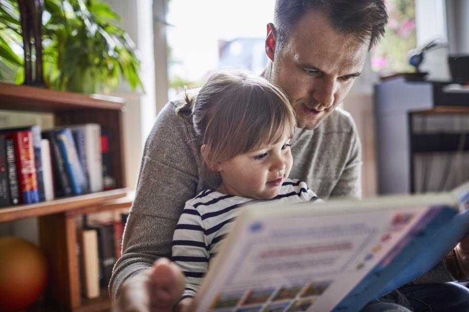 Dad reading to child | Getty