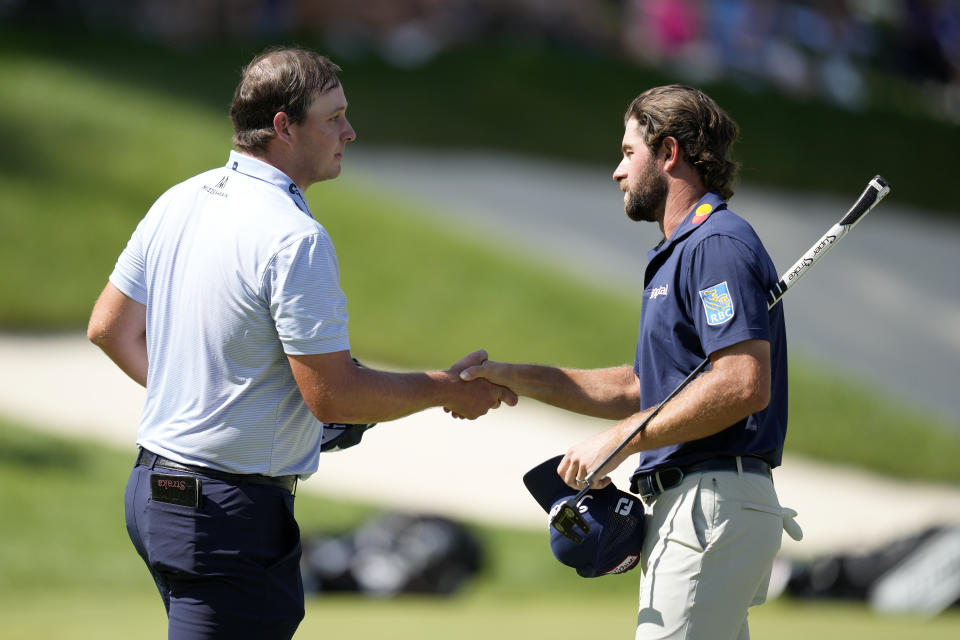 Sepp Straka, of Austria, greets Cameron Young, right, after finishing their final round of the John Deere Classic golf tournament, Sunday, July 9, 2023, at TPC Deere Run in Silvis, Ill. (AP Photo/Charlie Neibergall)