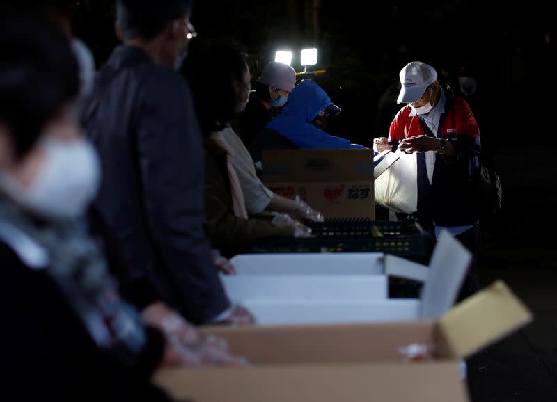 An elderly man receives food aid handouts, as the spread of the coronavirus disease (COVID-19) continues in Tokyo