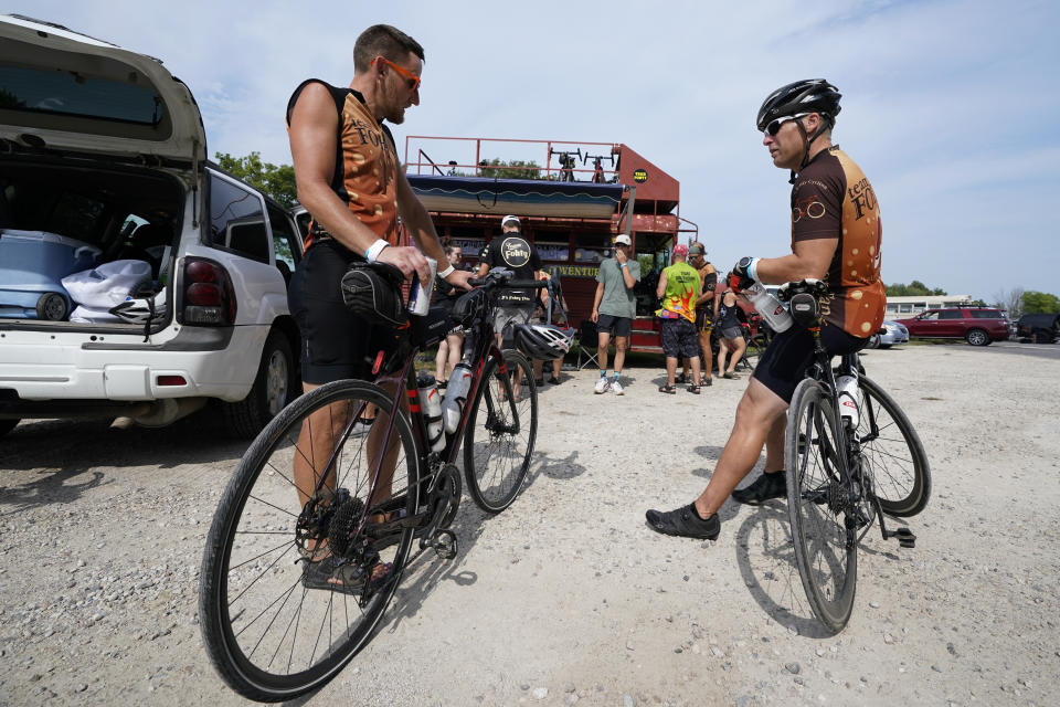 Associated Press reporter Dave Skretta, right, talks with a teammate Brian Talbot, of St. Louis, Mo., while taking a break from riding in The Des Moines Register's annual bike ride across Iowa, also known as RAGBRAI, Tuesday, July 25, 2023, in Rippey, Iowa. (AP Photo/Charlie Neibergall)