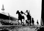 FILE - Herb Fisher, left, on Head Play, and Don Meade on Broker's Tip compete in the 59th Kentucky Derby at Churchill Downs in Louisville, Ky., May 6, 1933. They ran side-by-side down the stretch, with Meade and Fisher grabbing arms and whipping each other in what became known as the "fighting finish." The stewards declared Brokers Tip the winner by a nose. (Wallace Lowery/Courier Journal via AP, File)