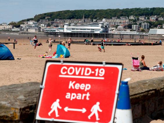 A sign displaying advice on social distancing is displayed at the beach in Weston-super-Mare, south west England on May 27, 2020, as lockdown measures are eased (ADRIAN DENNIS/AFP via Getty Images)