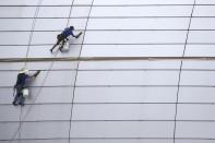 FILE - In this July 31, 2019, file photo workers clean the outside facade of State Farm Stadium in Glendale, Ariz. The shareholder comes first has for years been the mantra of the Business Roundtable, a group representing the most powerful CEOs in America. The group on Monday, Aug. 19, released a new mission statement that implies a foundational shift; a step back from shareholder primacy. (AP Photo/Ross D. Franklin, File)