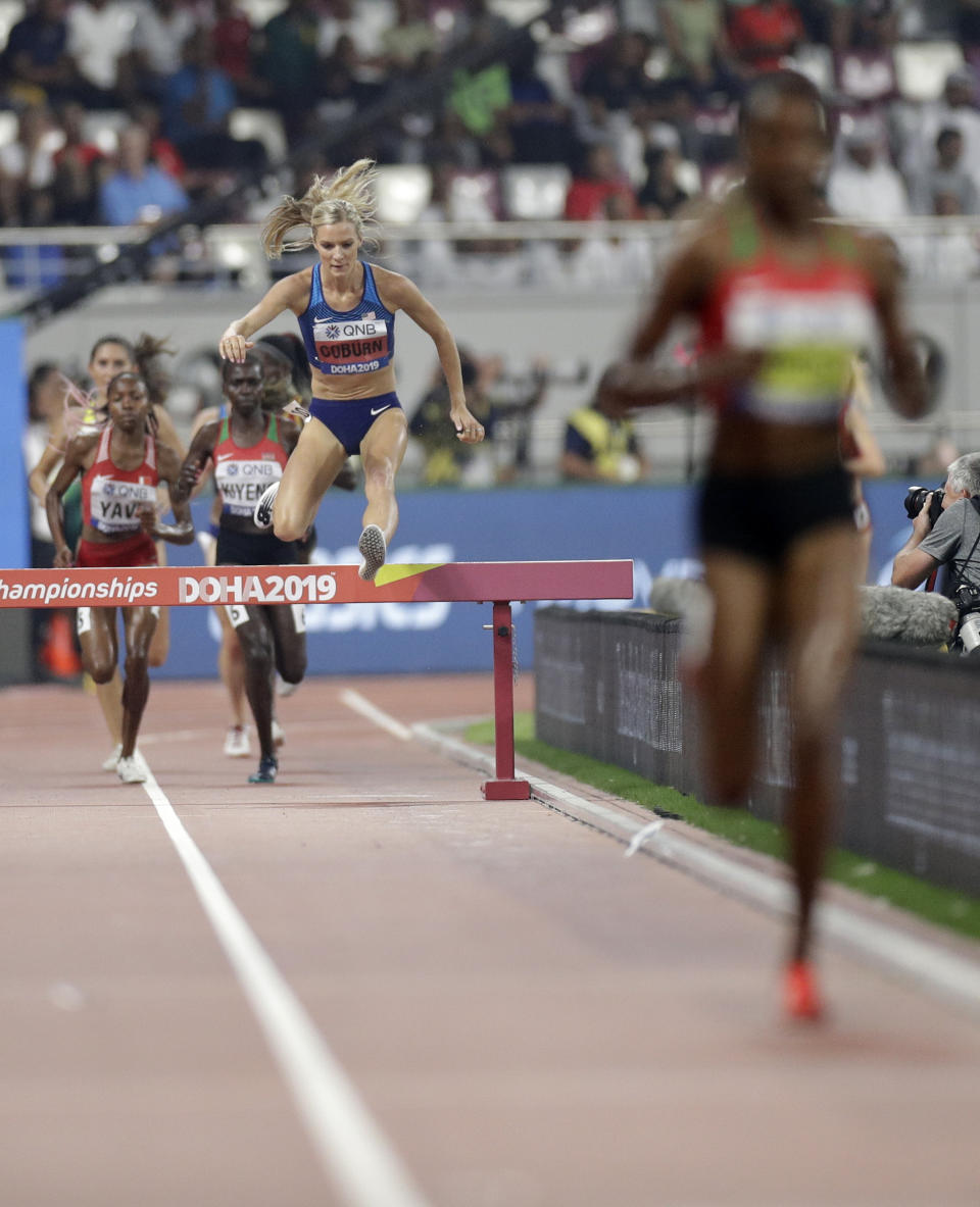 Emma Coburn, of the United States chases runaway leader Beatrice Chepkoech, of Kenya, the women's 3000 meter steeplechase final at the World Athletics Championships in Doha, Qatar, Monday, Sept. 30, 2019. (AP Photo/Petr David Josek)
