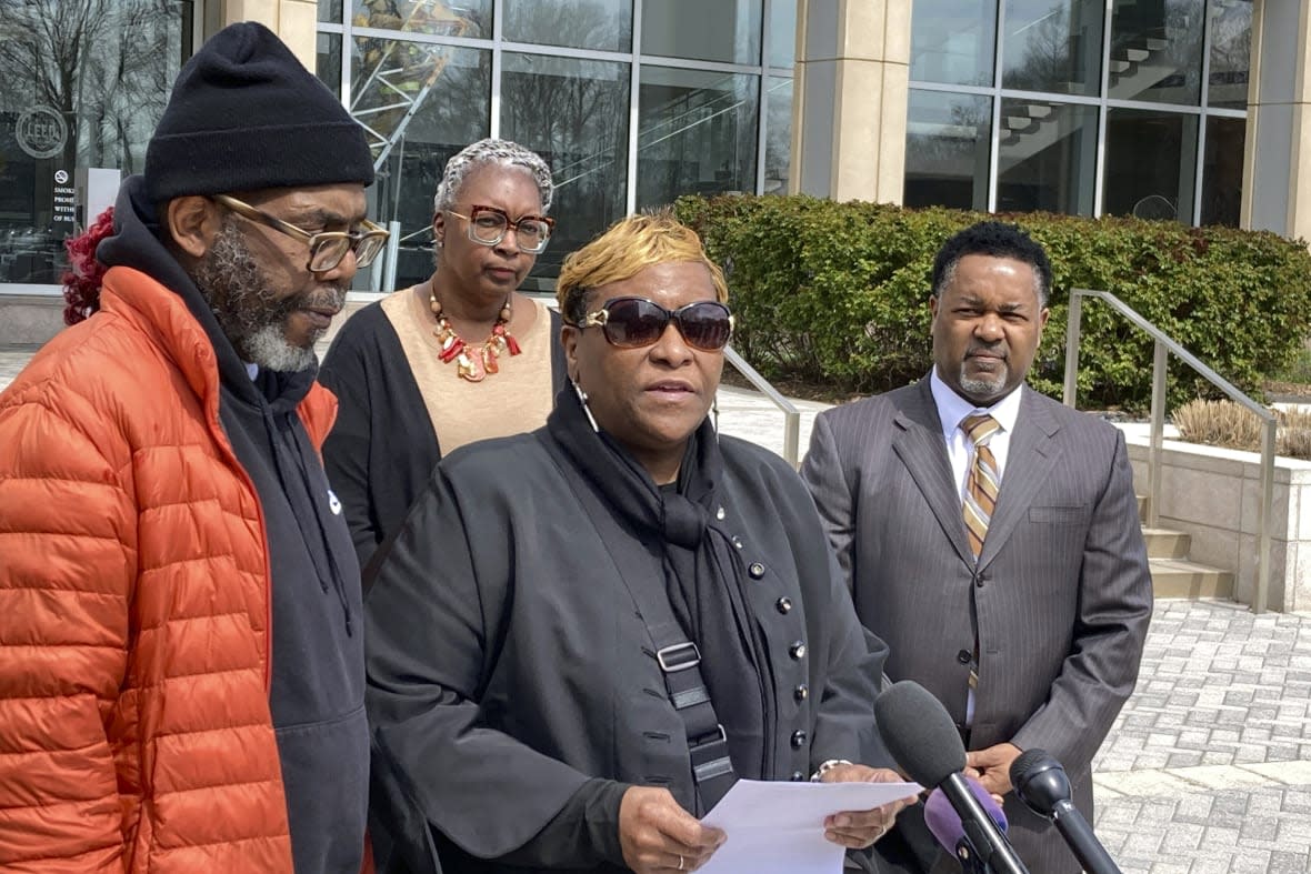 Timothy McCree Johnson’s parents Melissa Johnson, center, and Timothy Walker, left, address reporters along with attorney Carl Crews, right, outside Fairfax County Police headquarters, Wednesday, March 22, 2023, in Fairfax, Va., after viewing police body camera video of their son’s shooting death at the hands of police last month outside Tysons Corner Center shopping mall. (AP Photo/Matthew Barakat)