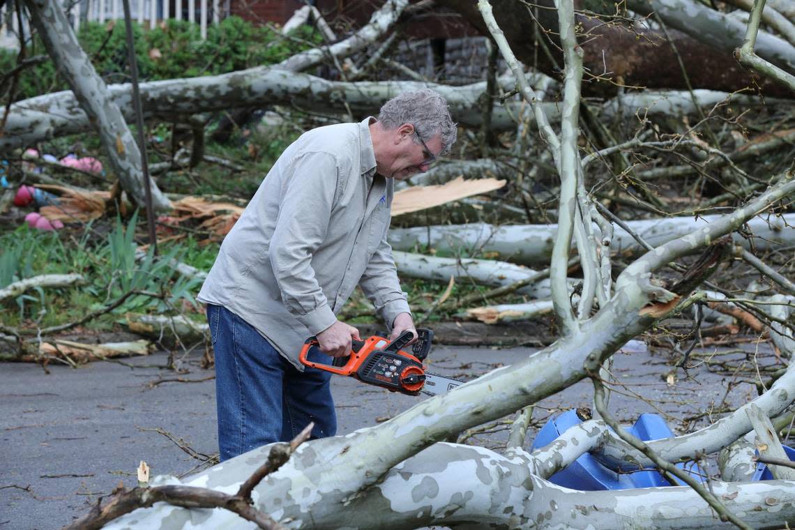 Fincastle Road resident, Frank Becker, begins removing debris on his own following a downed tree after a severe thunderstorm in Lexington, Ky on April 2, 2024.