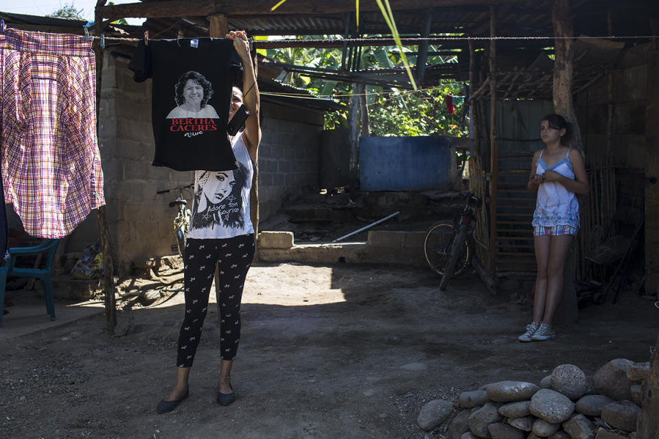 Marta Raquel Fernandez, 25, ambientalista y activista política, cuelga una playera con la imagen de Berta Cáceres, en el patio de su casa, en la aldea Gualojito, departamento de Santa Bárbara. Foto: Simone Dalmasso.