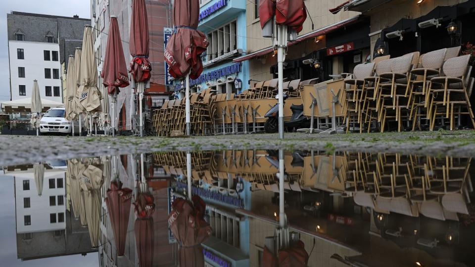 Zusammengestellte Tische und Stühle vor einem geschlossenen Lokal in Köln.