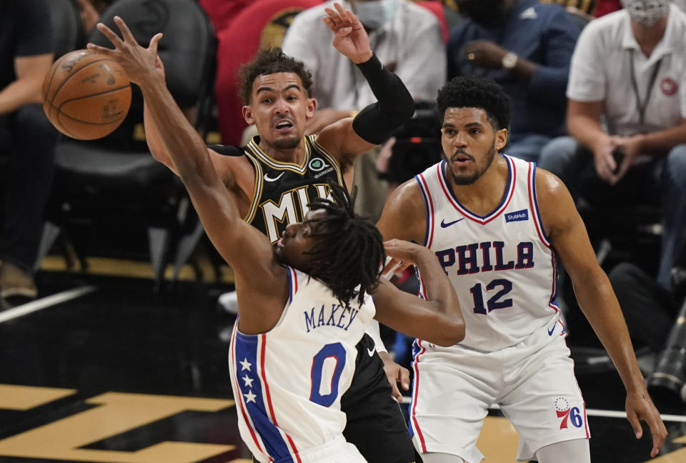 Atlanta Hawks' Trae Young, top left, passes the ball against Philadelphia 76ers' Tyrese Maxey (0) during the first half of Game 4 of a second-round NBA basketball playoff series on Monday, June 14, 2021, in Atlanta. (AP Photo/Brynn Anderson)