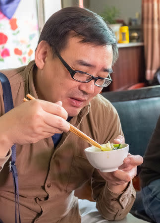 Yang Hengjun, author and former Chinese diplomat, who is now an Australian citizen, eats in an unspecified location in Tibet, China, mid-July, 2014 in this social media image obtained by REUTERS 