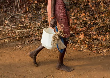 A woman carries an improvised plastic can to fetch water from a well outside Denganmal village, Maharashtra, April 20, 2015. REUTERS/Danish Siddiqui