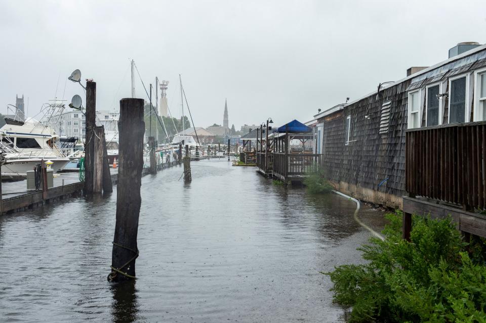 A pier minorly flooded in Connecticut, with the water at the same level as the entrance to a house.