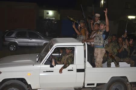 Tribal fighters and members of Iraqi security forces carry their weapons as they take part in an intensive security deployment in Dujail, north of Baghdad, June 16, 2014. REUTERS/Stringer