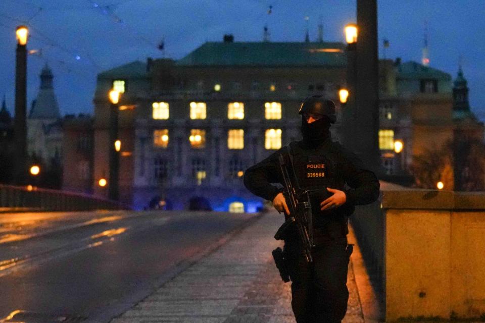 A police officer walks across a bridge over the Vltava river in downtown Prague, Czech Republic, Thursday, Dec. 21, 2023. Czech police say a shooting in downtown Prague has killed an unspecified number of people and wounded others. (AP Photo/Petr David Josek)