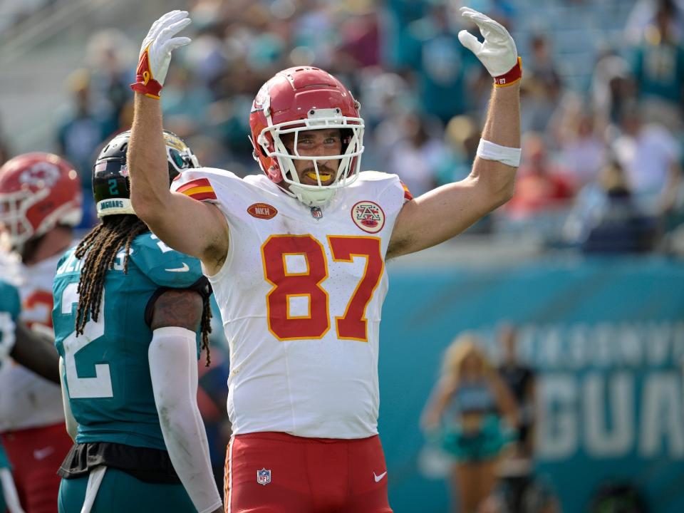 Travis Kelce motions to the crowd.