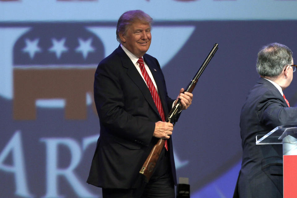 Republican presidential hopeful Donald Trump holds a Henry repeating rifle that was presented to him after he spoke at the Republican Party of Arkansas Reagan Rockefeller Dinner in Hot Springs, Ark., on July 17, 2015. (AP Photo/Danny Johnston)