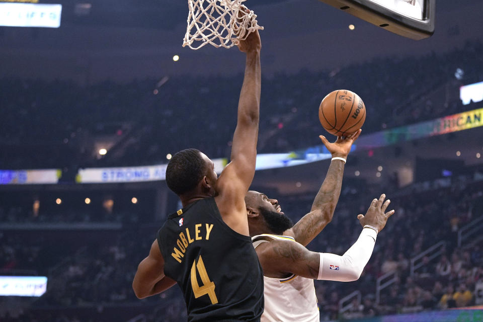 Los Angeles Lakers forward LeBron James, right, shoots in front of Cleveland Cavaliers forward Evan Mobley (4) during the first half of an NBA basketball game Saturday, Nov. 25, 2023, in Cleveland. (AP Photo/Sue Ogrocki)