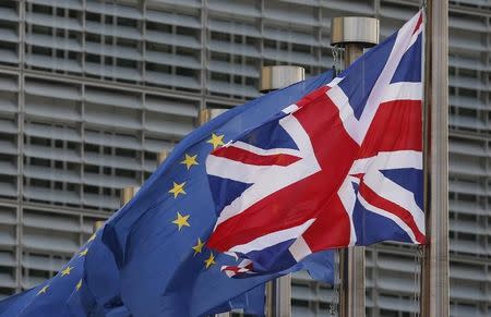 A Union Jack flag flutters next to European Union flags ahead of a visit of Britain's Prime Minister Theresa May and Britain's Secretary of State for Exiting the European Union David Davis at the European Commission headquarters in Brussels, Belgium October 16, 2017. REUTERS/ Francois Lenoir/ Files