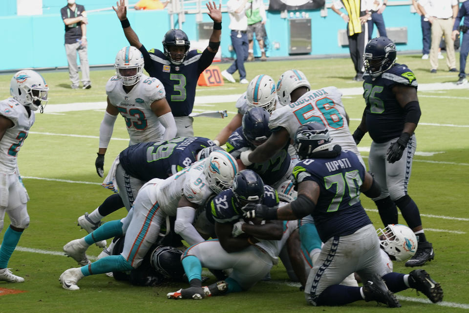 Seattle Seahawks running back Chris Carson (32) scores a touchdown during the second half of an NFL football game against the Miami Dolphins, Sunday, Oct. 4, 2020, in Miami Gardens, Fla. The Seahawks defeated the Dolphins 31-23.(AP Photo/Lynne Sladky)