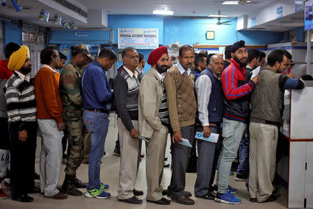 FILE PHOTO - People queue as they wait for their turn to exchange or deposit their old high denomination banknotes in Jammu, November 24, 2016. REUTERS/Mukesh Gupta/File Photo