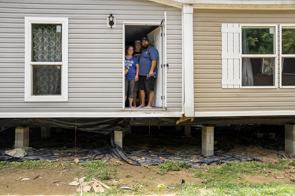 Image: Natasha Skidmore, Gregory Chase Hays, Brelyn Hays and Tatyn Skidmore  in the front door of their house in the Upper River Caney community of Lost Creek, Ky., on Aug. 18, 2022. (Michael Swensen for NBC News)