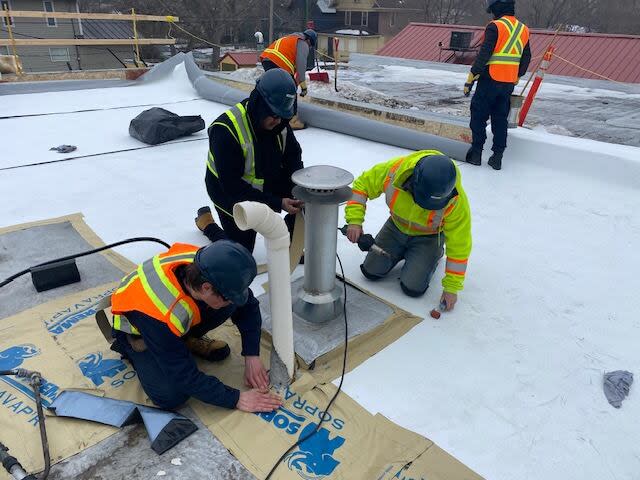 Students from the Regina Trades and Skills Centre work on replacing the roof at the Indigenous Christian Fellowship. (Submitted by Bert Adema  - image credit)