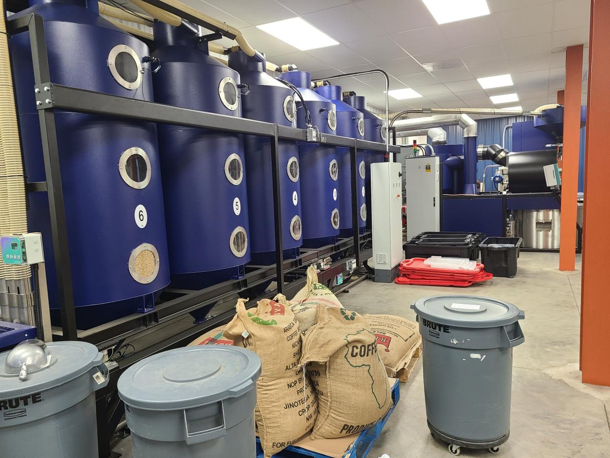 Six coffee silos are arranged to the left of the IMF recirculation roaster, which Denim Coffee purchased from Italy and has been using for about three months.