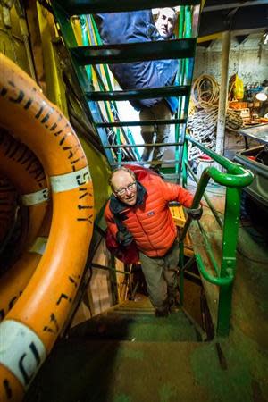 Chris Fogwill (bottom) and Chris Turney, co-leaders of the Australasian Antarctic Expedition, are pictured below deck in the front hold of the stranded Akademik Shokalskiy, as they prepare equipment in case of a helicopter evacuation, in Antarctica December 30, 2013. REUTERS/Andrew Peacock