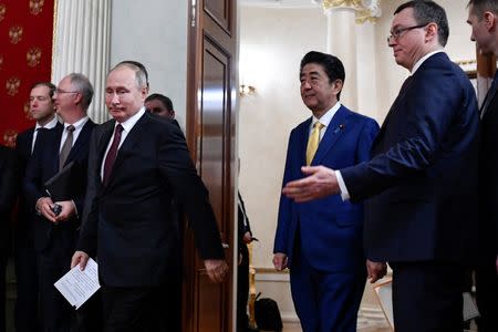 Russian President Vladimir Putin (L, front) and Japanese Prime Minister Shinzo Abe (3rd R) enter a hall before making a joint statement following their meeting at the Kremlin in Moscow, Russia January 22, 2019. Alexander Nemenov/Pool via REUTERS