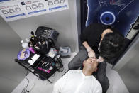 Yoshihiro Kamichi, a 44-year-old office worker, receives makeup and gets his hair done by a makeup artist at Ikemen-Works, a makeup salon for men, in Tokyo Wednesday, Feb. 3, 2021. The coronavirus pandemic has been pushing businesses to the edge in Japan, but some in the men's beauty industry have seen an unexpected expansion in their customer base. Japanese businessmen in their 40s, 50s and 60s who had little interest in cosmetics before the pandemic are now buying makeup. (AP Photo/Eugene Hoshiko)