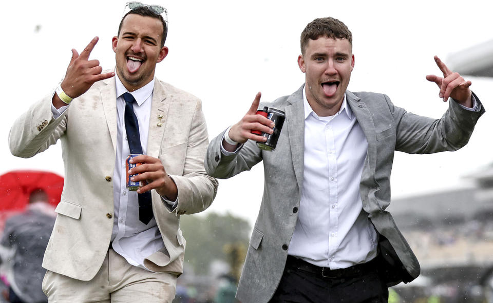 Racegoers, pictured here braving the rain.