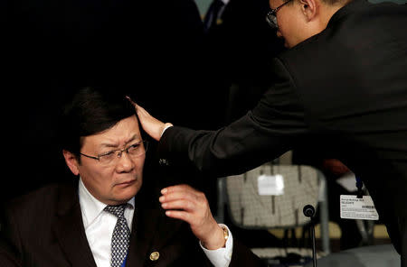 FILE PHOTO - An aid adjusts a hair of Chinese Finance Minister Lou Jiwei before the Development Committee meeting during the IMF/World Bank annual meetings in Washington, U.S., October 8, 2016. REUTERS/Yuri Gripas/File Photo