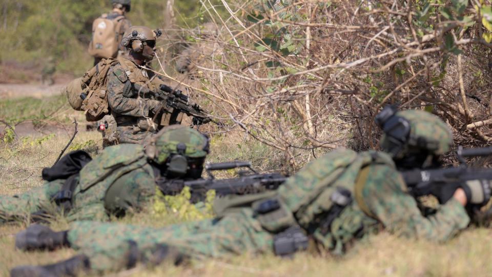 A U.S. Marine and and Singaporean soldiers take their positions during an amphibious landing operation at the Super Garuda Shield multi-national military exercise in Situbondo, East Java, Indonesia, Sunday, Sept. 10, 2023. (Trisnadi/AP)