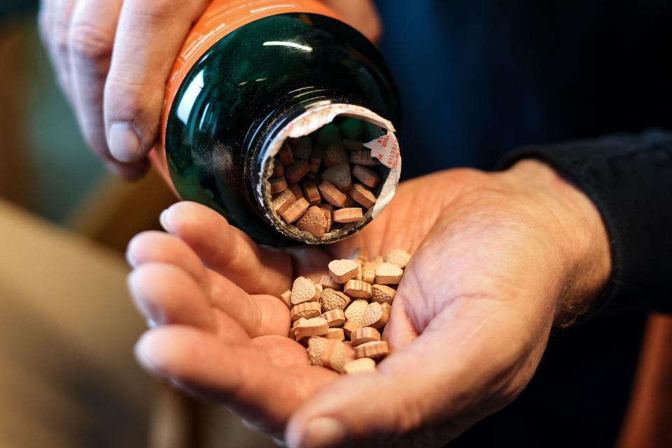 A Belgian customs officer open a bottle that contains ecstasy pills as he controls packages at Brussels Airport in Zaventem on April 6, 2023.  / Credit: KENZO TRIBOUILLARD/AFP via Getty Images