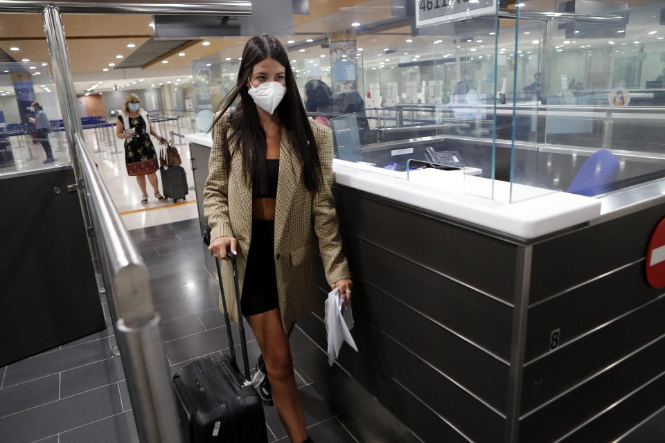 A female passenger wearing mask passes through the passport control on her arrival to Cyprus' main airport at Larnaca on Tuesday, June 9, 2020. Cyprus re-opened its airports on Tuesday to a limited number of countries after nearly three months of commercial air traffic as a result of a strict lockdown aimed at staving off the spread of COVID-19. (AP Photo/Petros Karadjias)