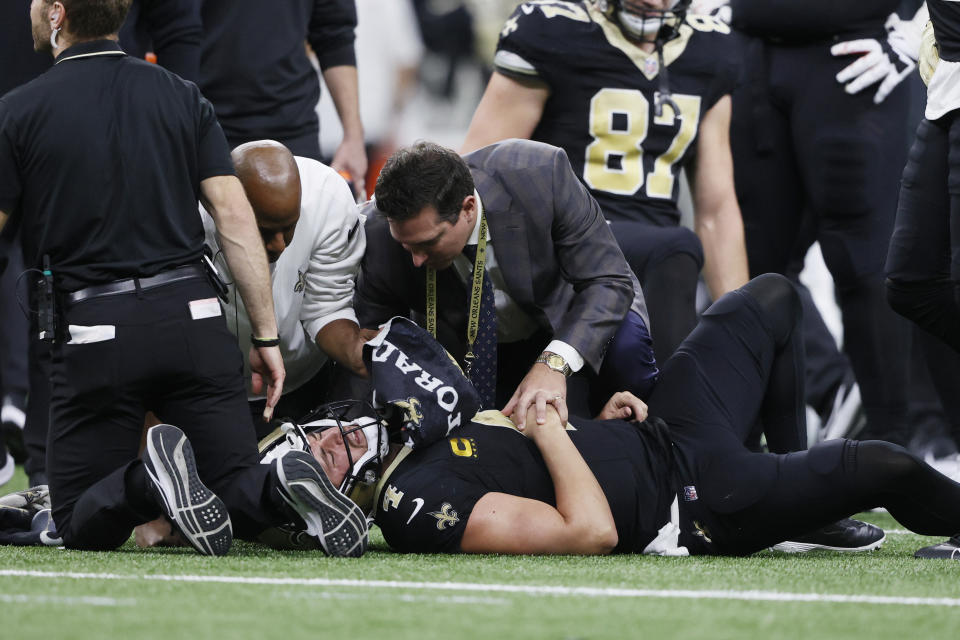 Medical personnel look over New Orleans Saints quarterback Derek Carr (4) after being tackled during the second half of an NFL football game against the Detroit Lions, Sunday, Dec. 3, 2023, in New Orleans. (AP Photo/Butch Dill)