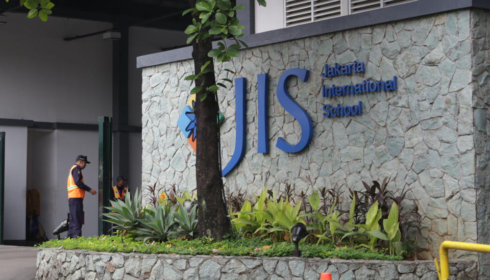 In this Thursday, May 8, 2014 photo, a security guard stands at the entrance of Jakarta International School (JIS) compound in Jakarta, Indonesia. U.S. citizen William Vahey taught here from 1992-2002. Vahey began his international teaching career with a series of stays around the Middle East and Europe, and by 1992, Vahey and his wife moved to Indonesia. He was one of the most beloved teachers in the world of international schools that serve the children of diplomats, well-off Americans and local elites. That was the public persona of William Vahey until a maid stole a memory drive from him in November. On it was evidence that Vahey molested scores of adolescent boys, possibly more. (AP Photo/Achmad Ibrahim)