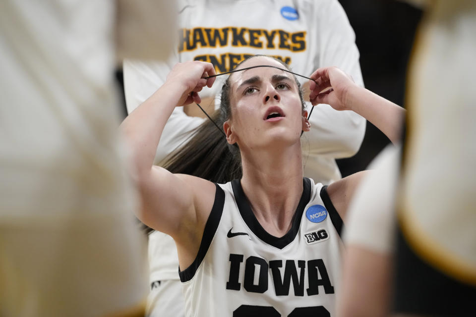 Iowa guard Caitlin Clark (22) adjusts her headband during the first half of a first-round college basketball game against Holy Cross in the NCAA Tournament, Saturday, March 23, 2024, in Iowa City, Iowa.  (AP Photo/Matthew Putney)