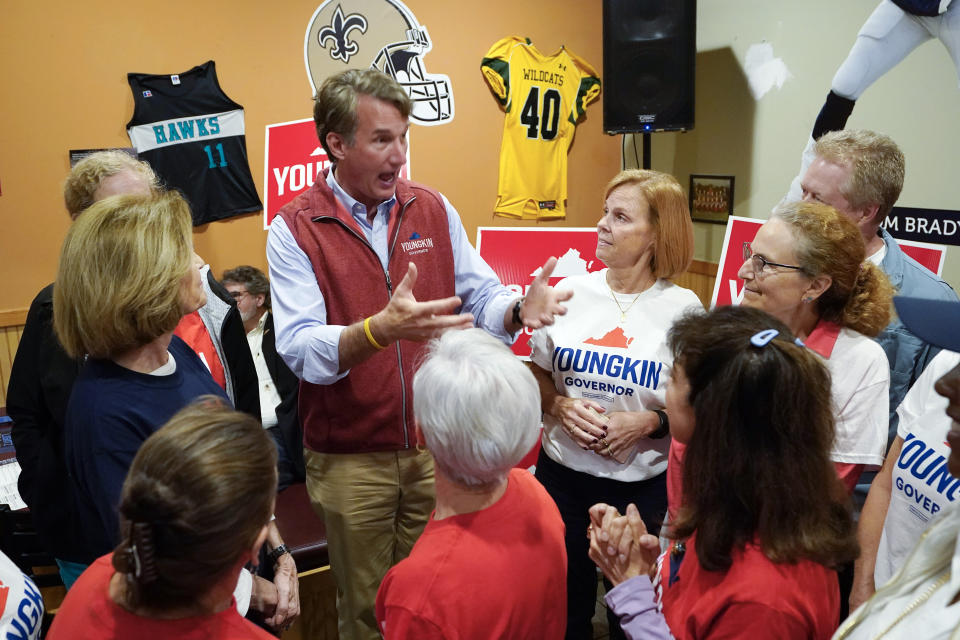 FILE - In this Oct. 11, 2021, file photo Virginia Republican gubernatorial candidate Glenn Youngkin greets supporters during a meet and greet at a sports bar in Chesapeake, Va. Youngkin faces former Governor Terry McAuliffe in the November election. Youngkin’s suburban strategy emphasizes his every-man image and “kitchen-table” issues like taxes, public safety and education, while largely avoiding former President Donald Trump. (AP Photo/Steve Helber, File)