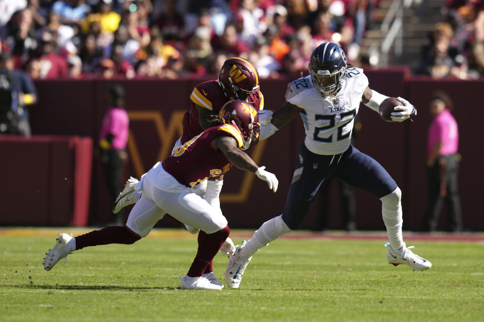 Tennessee Titans running back Derrick Henry, right, rushes past Washington Commanders defenders in the first half of an NFL football game, Sunday, Oct. 9, 2022, in Landover, Md. (AP Photo/Jess Rapfogel)