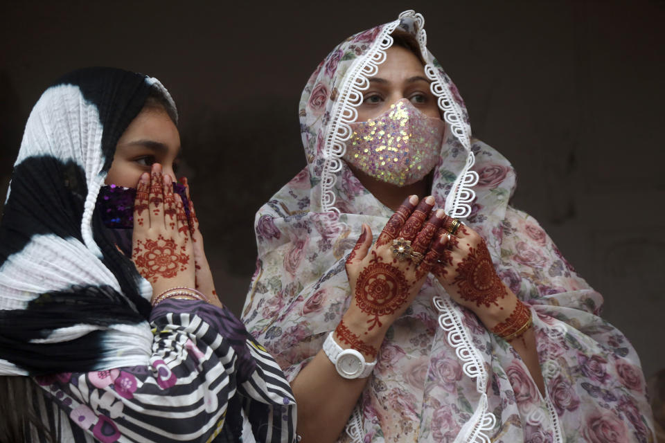 Muslim women with their hands painted with traditional henna pray during an Eid al-Fitr prayer at historical Badshahi mosque, in Lahore, Pakistan, Thursday, May 13, 2021. Millions of Muslims across the world are marking a muted and gloomy holiday of Eid al-Fitr, the end of the fasting month of Ramadan, a usually joyous three-day celebration that has been significantly toned down as coronavirus cases soar. (AP Photo/K.M. Chaudary)