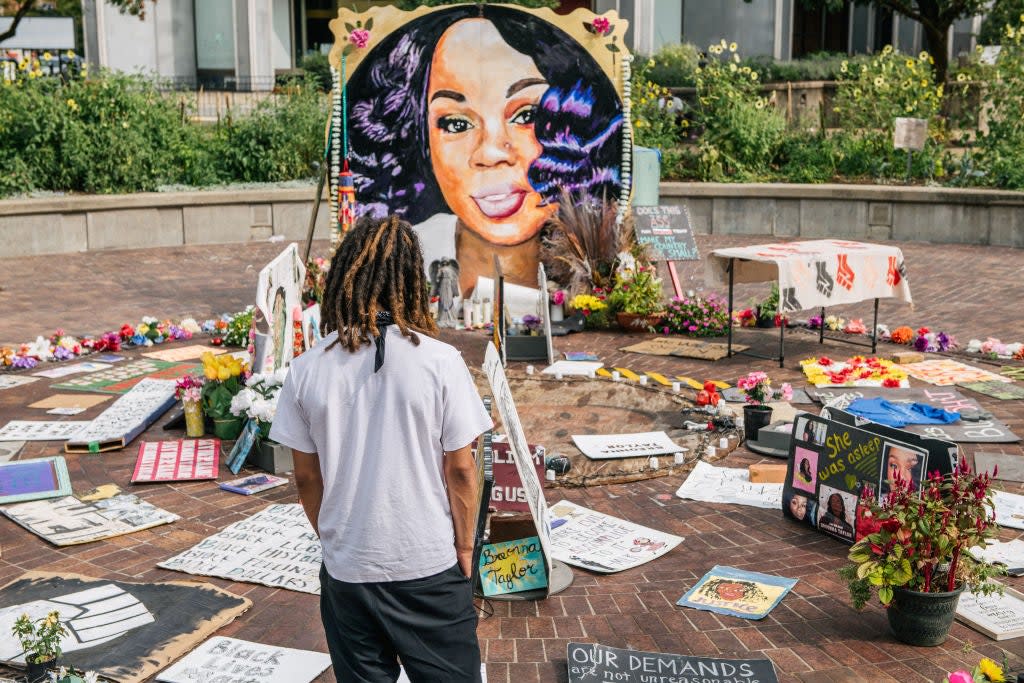 A man looks over a memorial dedicated to Breonna Taylor , who was killed during a police raid on her home (Getty Images)