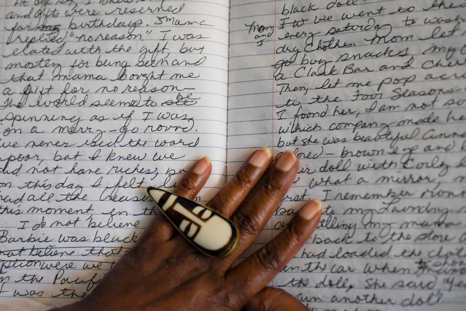 Glenis Redmond, Greenville's first poet laureate, shows her composition book where she writes in her living room on Wednesday, Aug. 9, 2023.