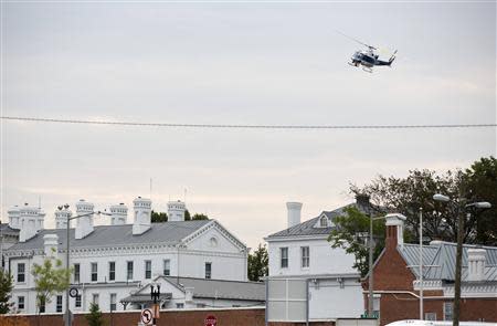 A police helicopter flies over the Washington Navy Yard as police respond to a shooting, in Washington September 16, 2013. REUTERS/Joshua Roberts