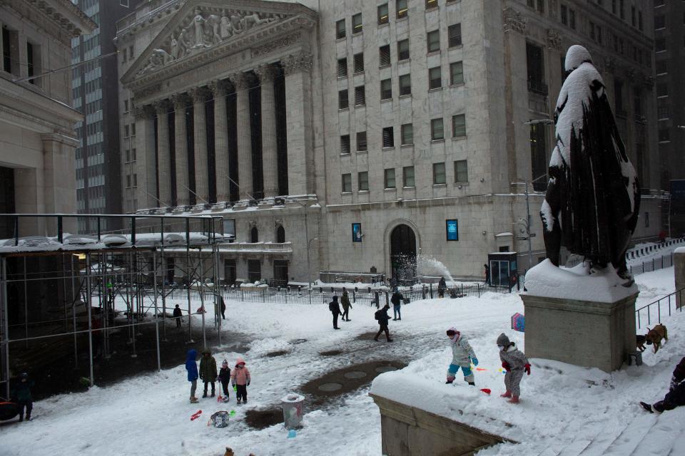 People play as snow falls in Wall Street during a winter storm on February 1, 2021 in New York City. - A powerful winter storm is set to dump feet of snow along a stretch of the US east coast including New York City on February 1, 2021, after blanketing the nation's capital. The National Weather Service issued storm warnings from Virginia to Maine -- a swathe home to tens of millions of people -- and forecast snowfall of 18 to 24 inches (45-60 centimeters) in southern New York, northeastern New Jersey and parts of southwest Connecticut. (Photo by Kena Betancur / AFP) (Photo by KENA BETANCUR/AFP via Getty Images)