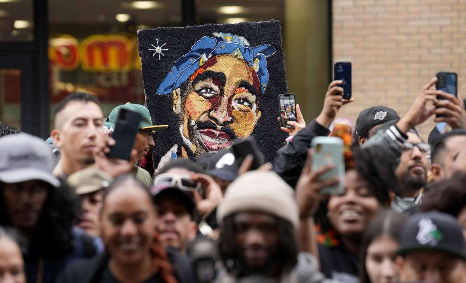 FILE - An image of Tupac Shakur appears among fans during a ceremony honoring Shakur with a star on the Hollywood Walk of Fame on June 7, 2023, in Los Angeles. Duane “Keffe D” Davis charged with killing Tupac Shakur in 1996 will have a lawyer from one of Las Vegas’ best-known political families with him when he appears in court Thursday, Oct. 19, on a murder charge. Ross Goodman said Wednesday, Oct. 18, he'll appear with Davis but will seek two more weeks to confirm as his attorney. (AP Photo/Chris Pizzello, File)