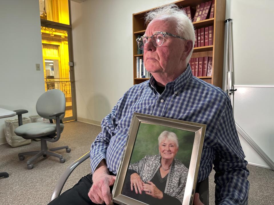 Michael Kruzich holds a photo of his late mother Donna during an interview Monday, April 15, 2024, in Lansing, Mich. Donna Kruzich was one of dozens of people in the U.S. who died after being injected with tainted steroids made by a specialty pharmacy in Massachusetts. Now, more than a decade later, the operator of the New England Compounding Center is returning to a Michigan court to be sentenced on involuntary manslaughter charges. (AP Photo/Mike Householder)