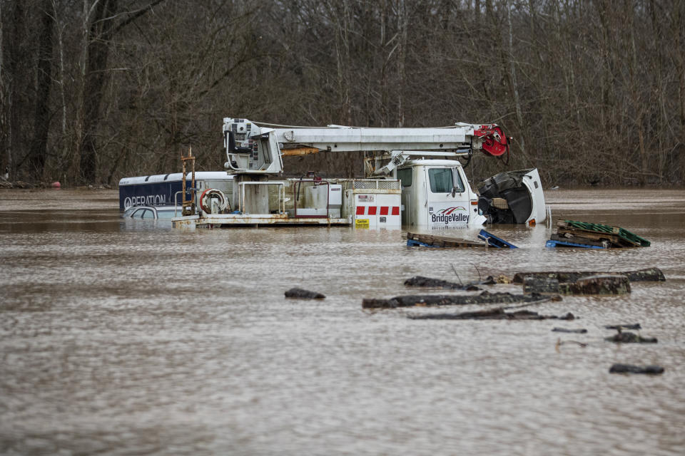 Foodwater from the Mud River covers vehicles at the Milton Flea Market on Friday, Feb. 17, 2023, in Milton, W.Va. (Kyle Phillips/The Herald-Dispatch via AP)