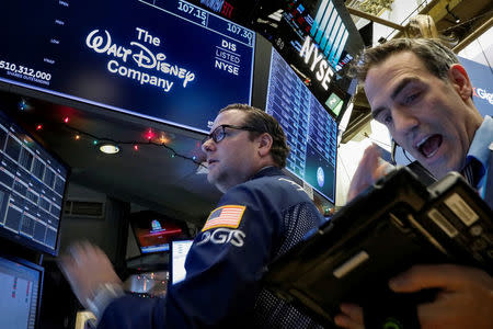 Traders work at the post where Walt Disney Co. stock is traded on the floor of the New York Stock Exchange (NYSE) in New York, U.S., December 14, 2017. REUTERS/Brendan McDermid